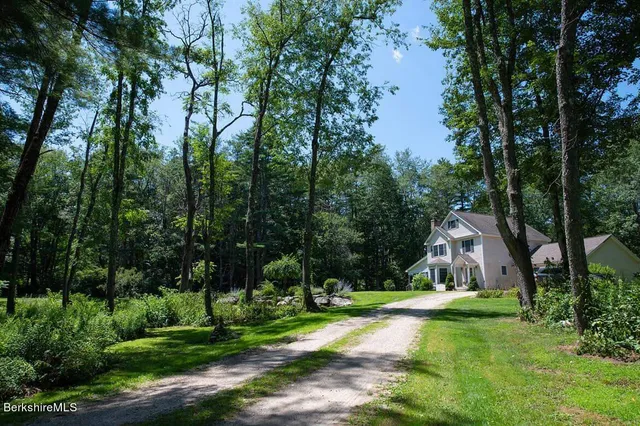 an empty room with wooden floor fireplace and windows