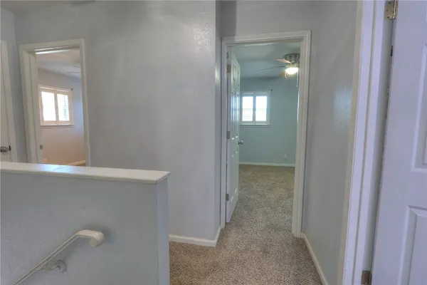 a view of a hallway with wooden cabinets