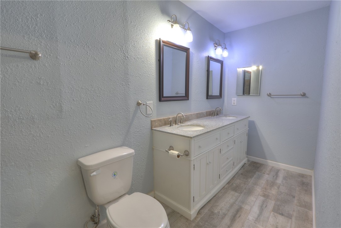 3141 Baybrook Drive Corpus Christi, TX 78418 - Photo 26 of 32 a bathroom with a granite countertop sink toilet and mirror