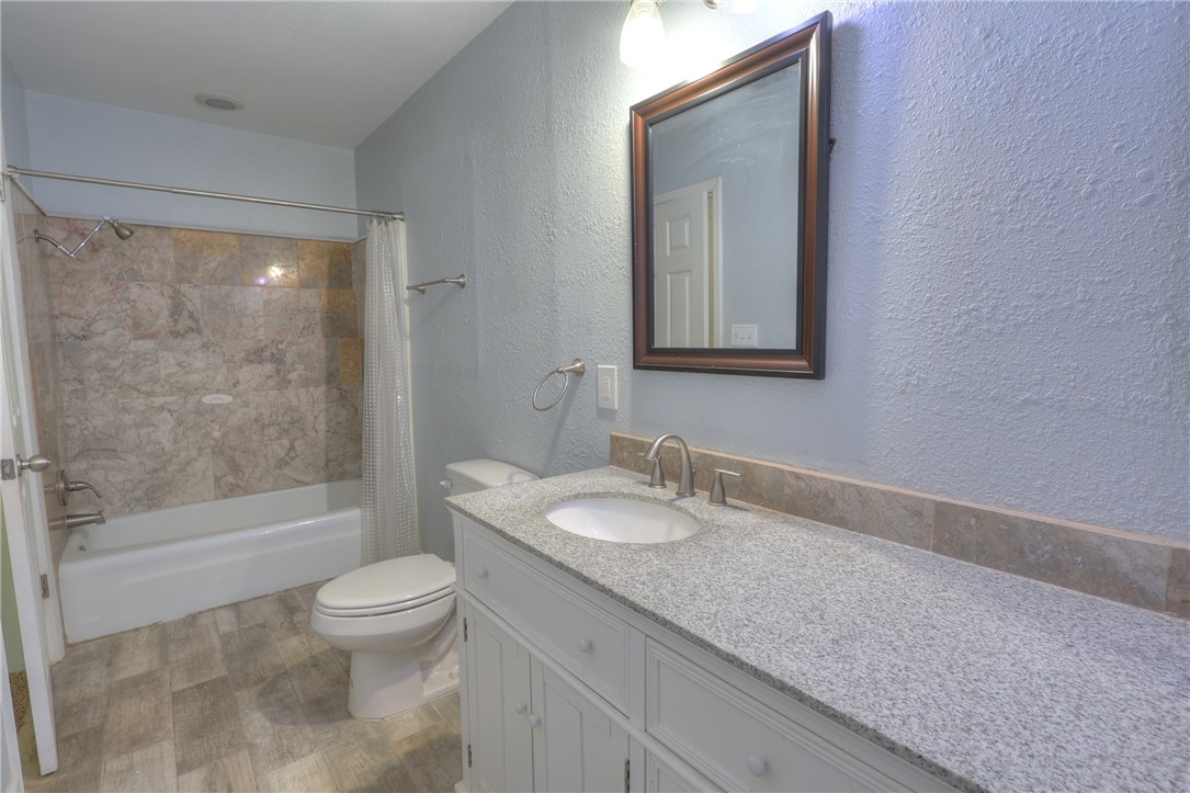 3141 Baybrook Drive Corpus Christi, TX 78418 - Photo 27 of 32 a bathroom with a granite countertop sink a toilet and shower