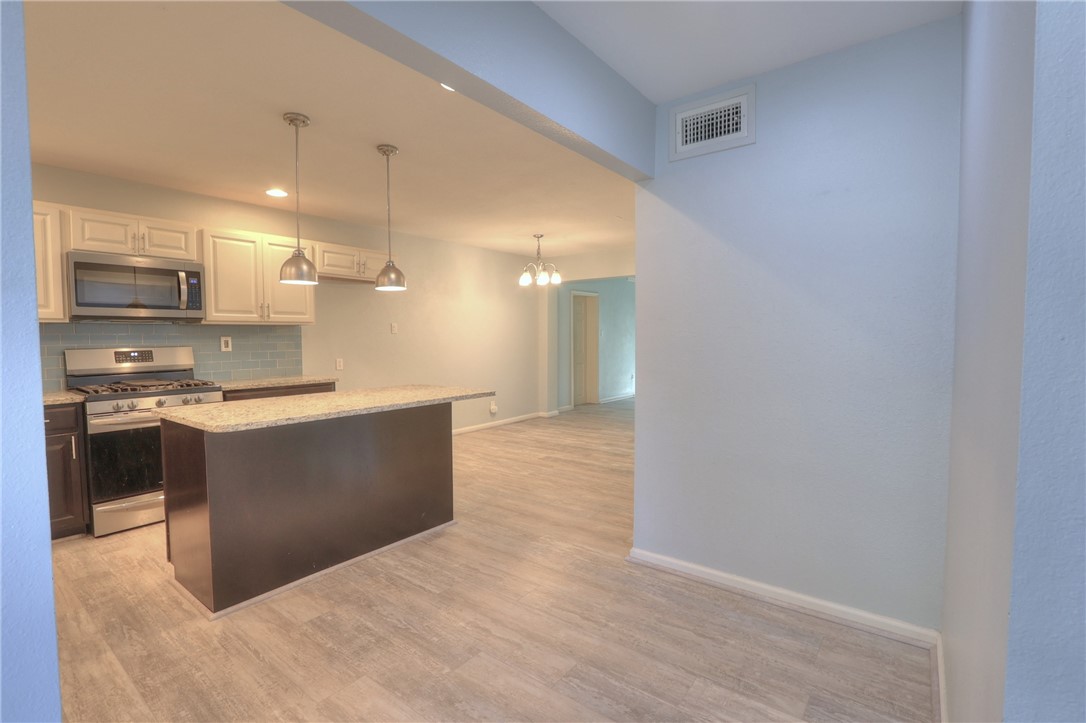 3141 Baybrook Drive Corpus Christi, TX 78418 - Photo 5 of 32 a large kitchen with kitchen island a sink stainless steel appliances and cabinets