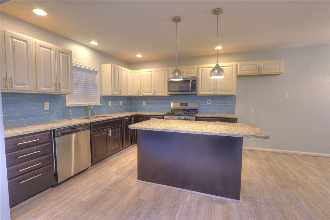 3141 Baybrook Drive Corpus Christi, TX 78418 - Photo 6 of 32 a kitchen with stainless steel appliances granite countertop a sink a stove and a wooden floors