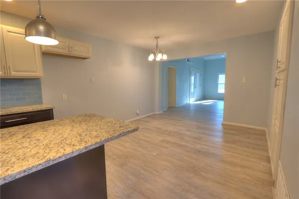 a view of a kitchen with a sink and chandelier