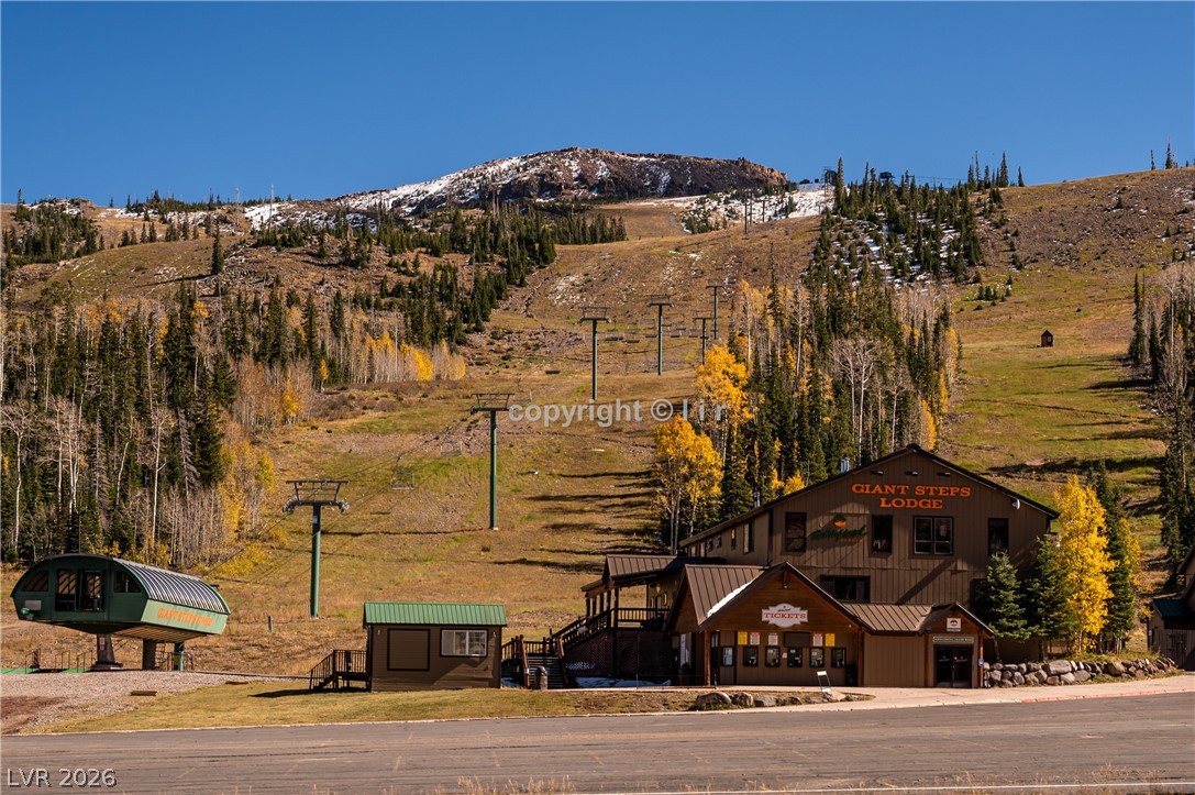 407 South Vasels Road, Unit 49 Brian Head, UT 84719 - Photo 32 of 45 Towering mountain peaks rise behind the rustic resort structures and lift lines.