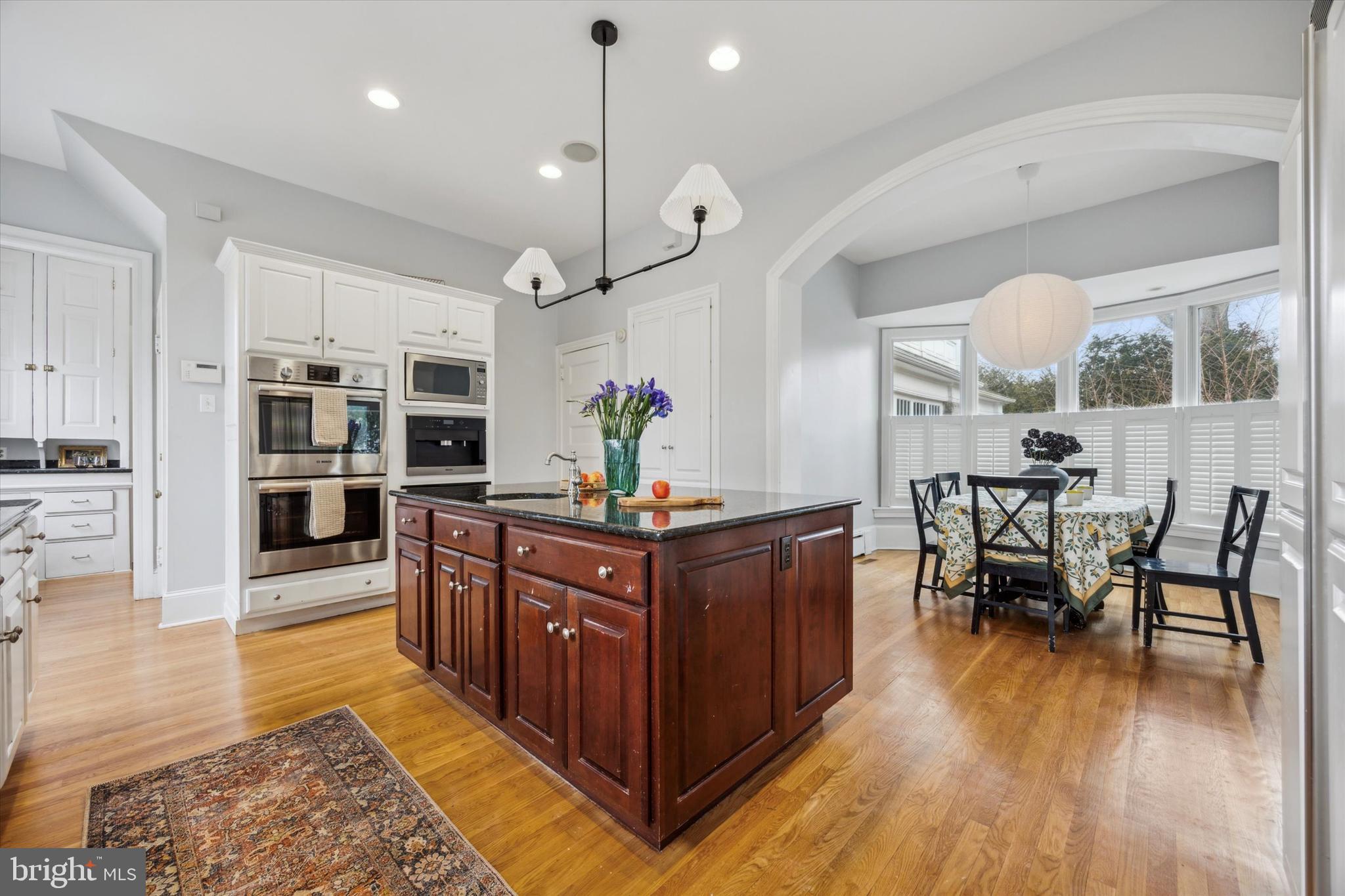 226 Fishers Road Bryn Mawr, PA 19010 - Photo 11 of 60 a kitchen with stainless steel appliances granite countertop dining table chairs and wooden floor