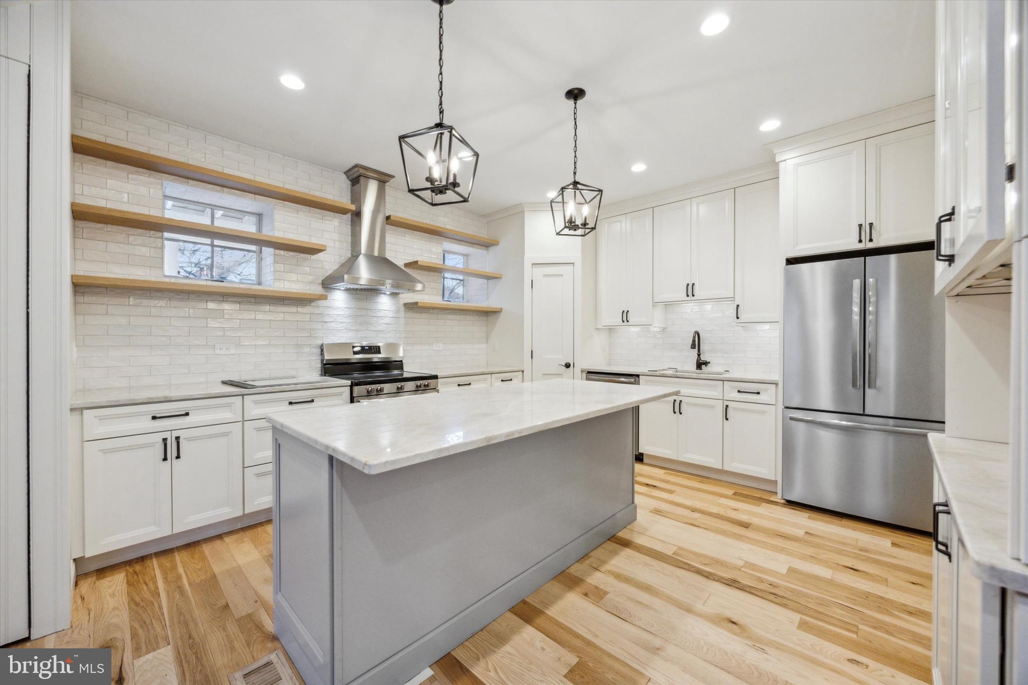226 Fishers Road Bryn Mawr, PA 19010 - Photo 45 of 60 a kitchen with stainless steel appliances granite countertop a sink a stove a refrigerator and island with wooden floor