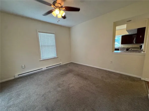 an empty room with windows and a chandelier fan