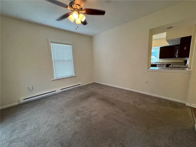 an empty room with windows and a chandelier fan