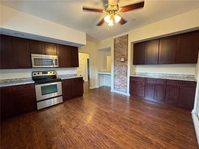 a kitchen with a refrigerator and a stove top oven