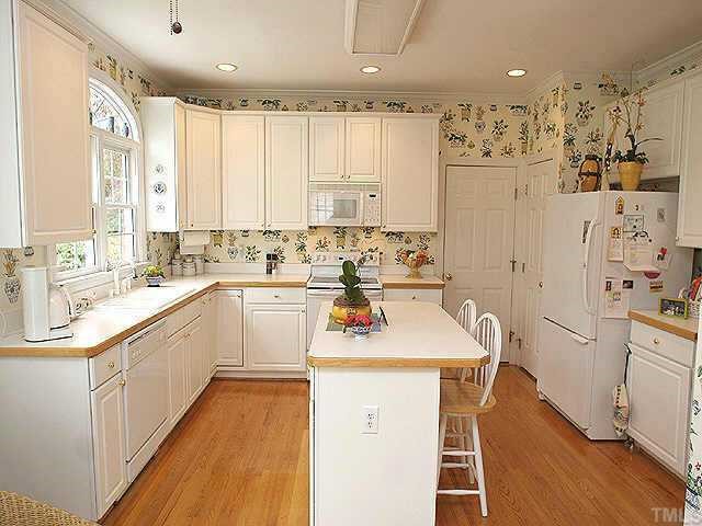 7709 Wilderness Road Raleigh, NC 27613 - Photo 4 of 8 a kitchen with stainless steel appliances sink a stove and white cabinets