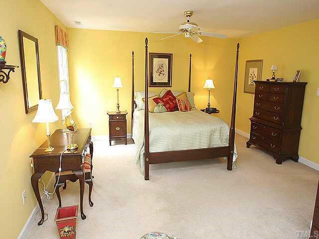 7709 Wilderness Road Raleigh, NC 27613 - Photo 7 of 8 a bedroom with a bed window and mirror