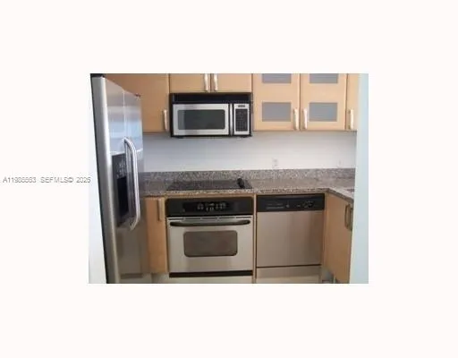 a kitchen with stainless steel appliances granite countertop a refrigerator a stove and a sink