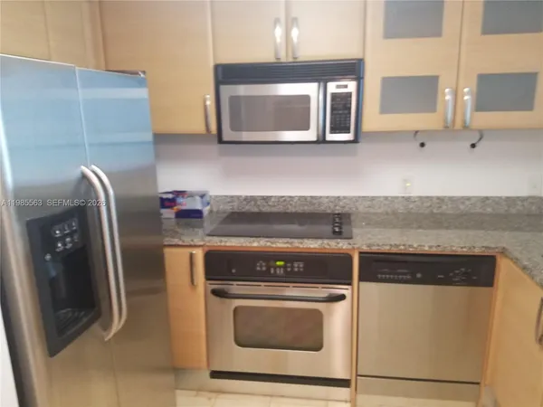a kitchen with stainless steel appliances a stove microwave and sink