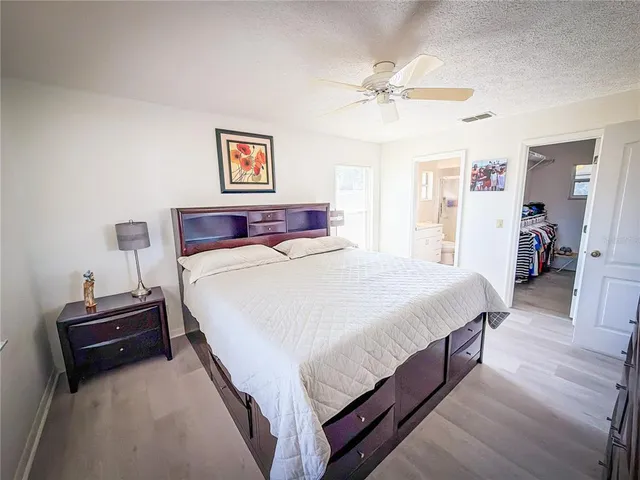 a spacious bedroom with a bed and a chandelier