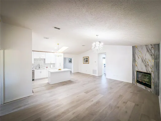 an empty room with fireplace and wooden floor