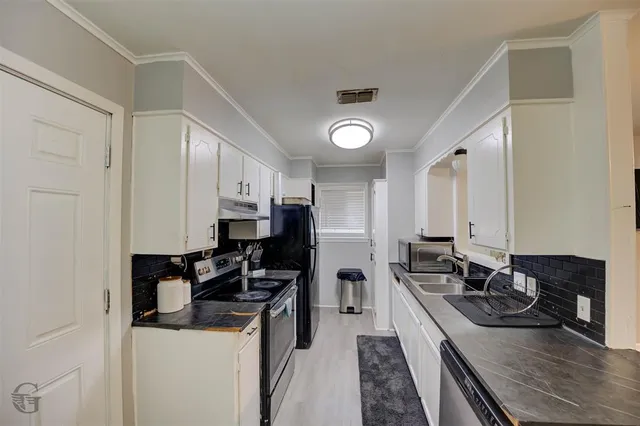 a kitchen with a sink stove top oven and refrigerator