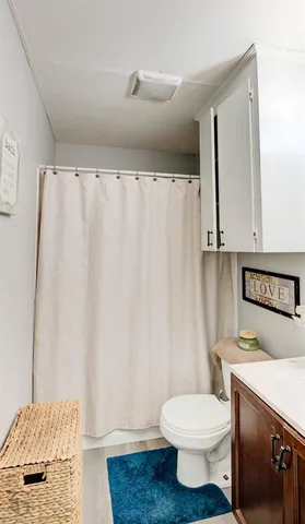 a bathroom with a toilet and a shower