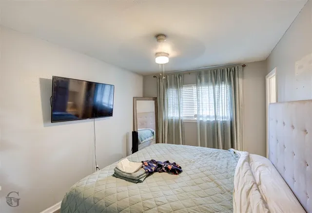 a bedroom with a bed and a flat screen tv