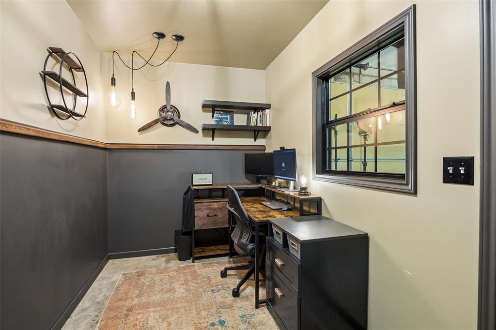11211 Emerald Ranch Lane Forney, TX 75126 - Photo 6 of 35 Dedicated office inside workshop featuring a window with dark trim, two-tone painted walls with a wood trim accent, and industrial-style exposed bulb pendant lighting