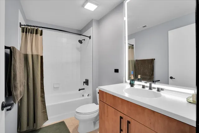 a bathroom with a double vanity sink toilet mirror and shower