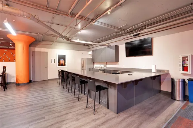 a kitchen with stainless steel appliances granite countertop a stove a refrigerator and a dining table with wooden floor