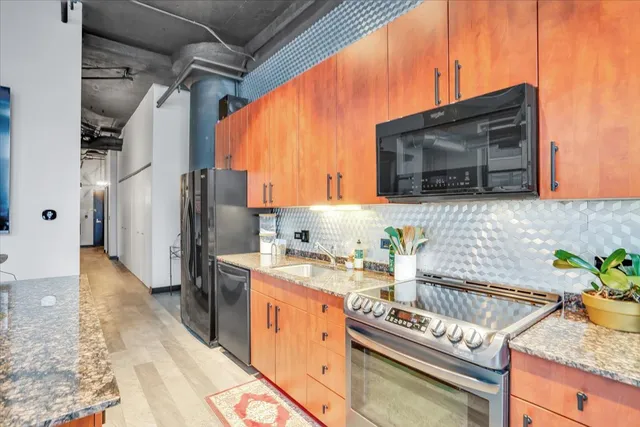 a kitchen with stainless steel appliances granite countertop a stove and a microwave