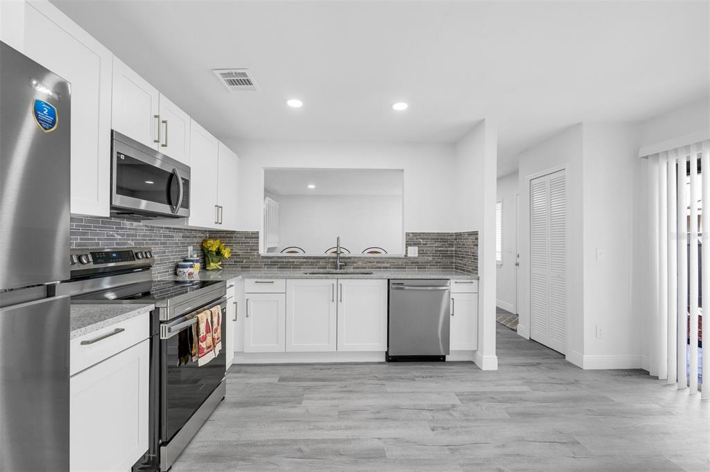 4402 Ring Neck Road, Unit 19B Orlando, FL 32808 - Photo 14 of 35 a kitchen with a sink stove top oven and cabinets