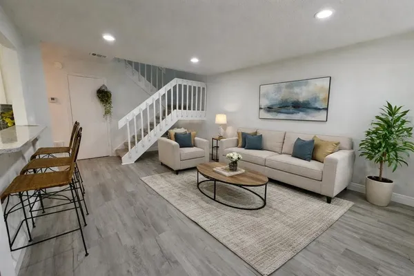 a living room with furniture and wooden floor