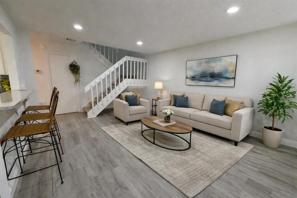 4402 Ring Neck Road, Unit 19B Orlando, FL 32808 - Photo 2 of 35 a living room with furniture and wooden floor