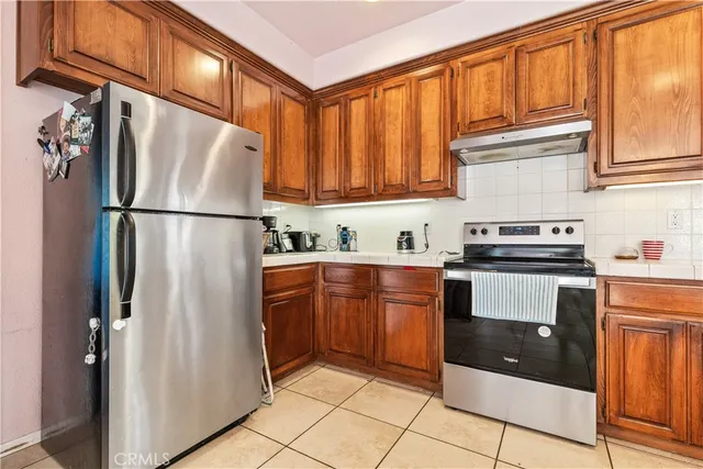 a kitchen with stainless steel appliances granite countertop a refrigerator and a sink