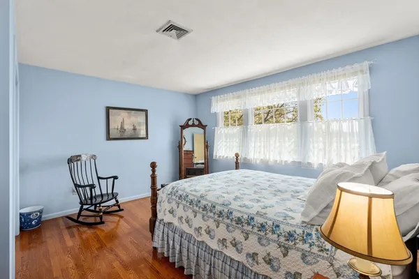 a bedroom with a bed a chair and a large window