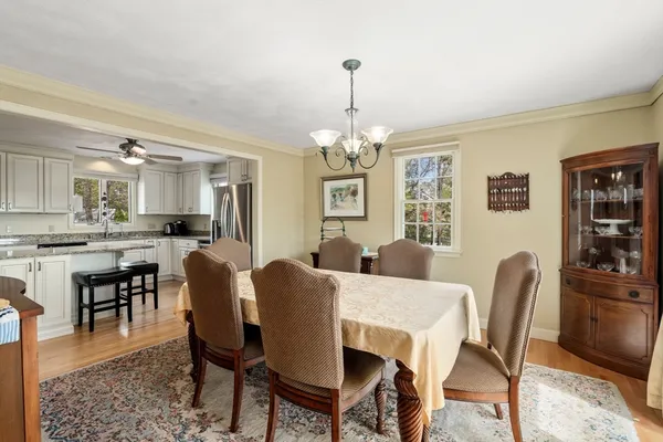 a dining room with furniture a chandelier and wooden floor