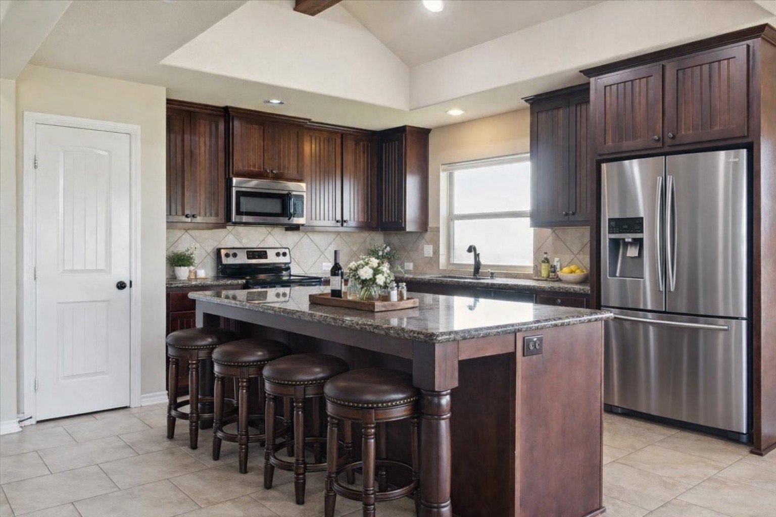 a kitchen with kitchen island granite countertop wooden cabinets a refrigerator a stove a sink and a oven with wooden floor