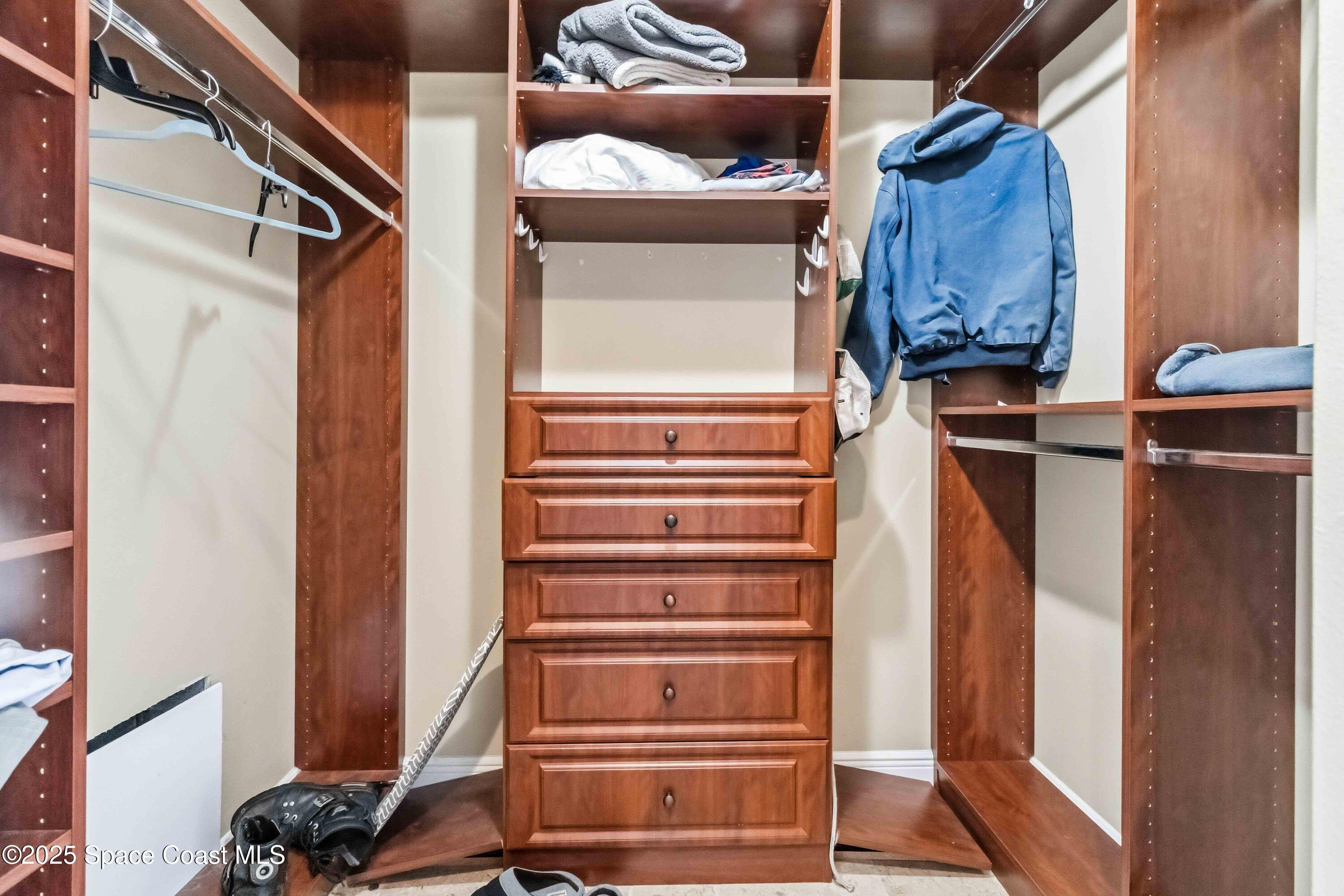 4125 West End Road, Unit 306 Cocoa Beach, FL 32931 - Photo 23 of 51 a view of walk in closet with clothes and shoes