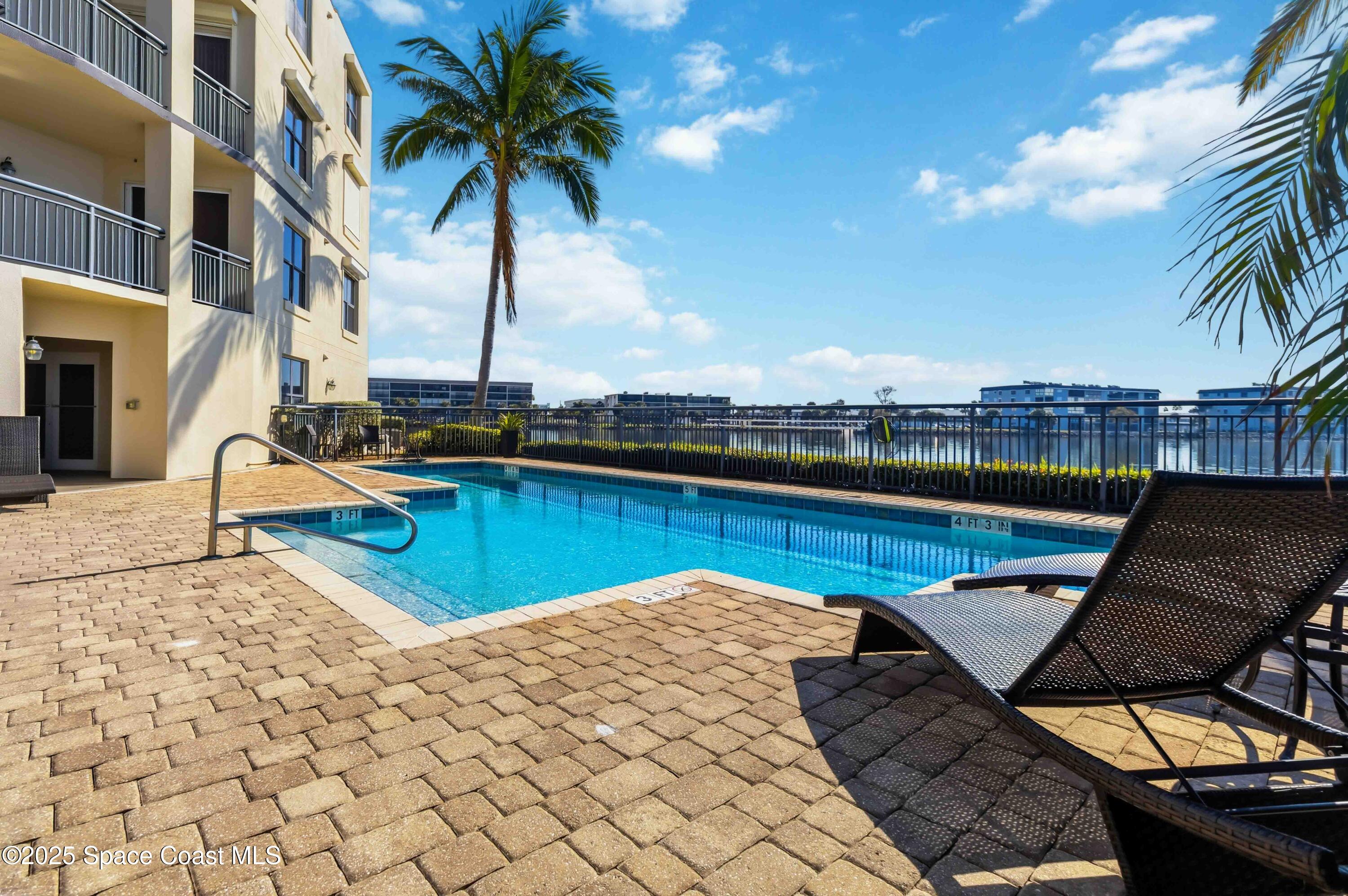 4125 West End Road, Unit 306 Cocoa Beach, FL 32931 - Photo 28 of 51 a view of a swimming pool with a lounge chair