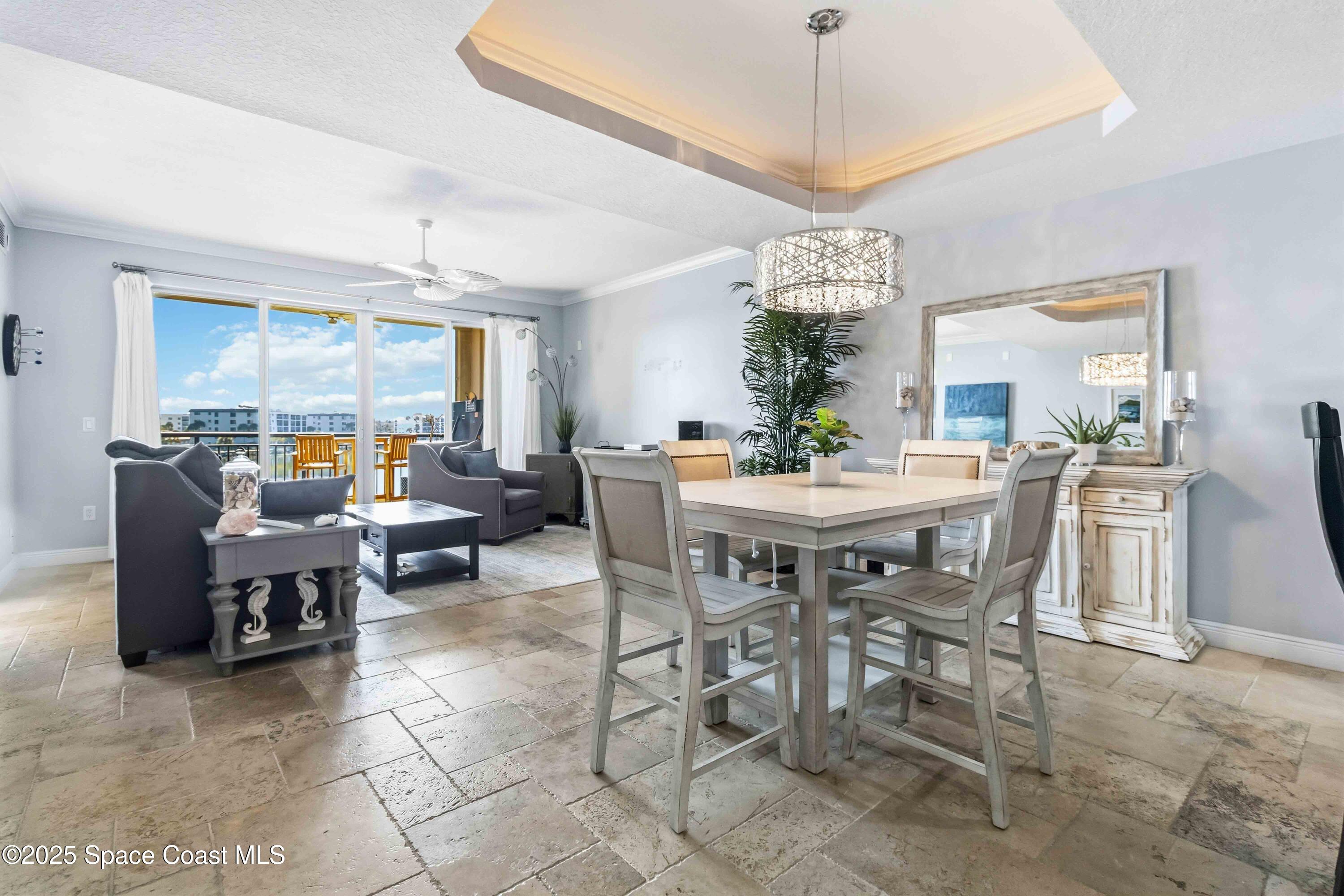 4125 West End Road, Unit 306 Cocoa Beach, FL 32931 - Photo 8 of 51 a dining room with furniture a chandelier and window