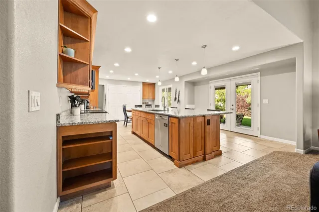 a open kitchen with kitchen island a sink a stove and a refrigerator with wooden floor