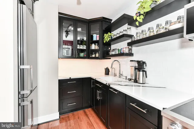a kitchen with stainless steel appliances granite countertop a sink and a refrigerator