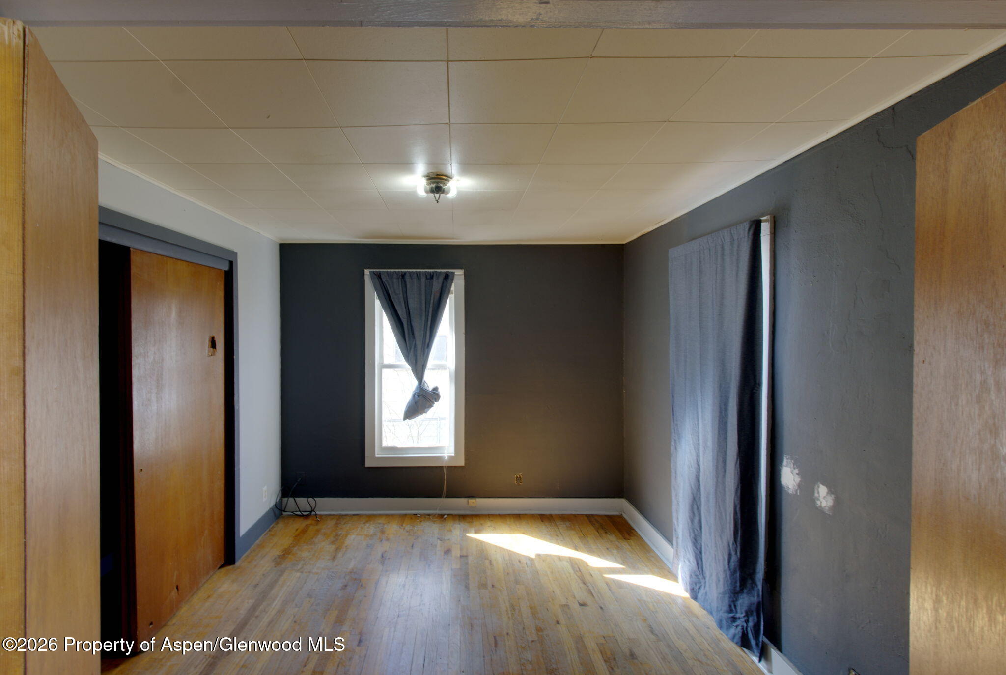 995 Colorado Street Craig, CO 81625 - Photo 9 of 21 an empty room with wooden floor and windows