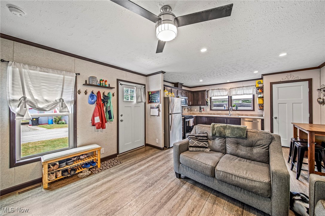 202 West Main Road, Unit LOT 13 Conneaut, OH 44030 - Photo 7 of 23 Living room with ornamental molding, light wood-type flooring, a textured ceiling, a ceiling fan, and recessed lighting
