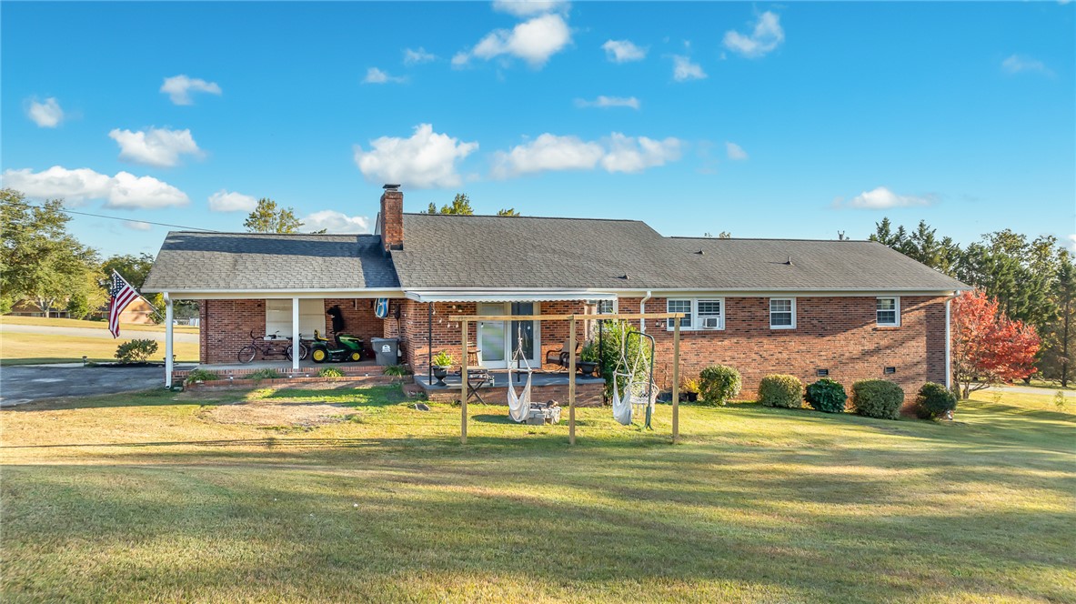 401 South Glassy Mountain Road Pickens, SC 29671 - Photo 31 of 37 This classic brick residence features a welcoming porch, lush lawn, and mature landscaping under a brilliant sky.