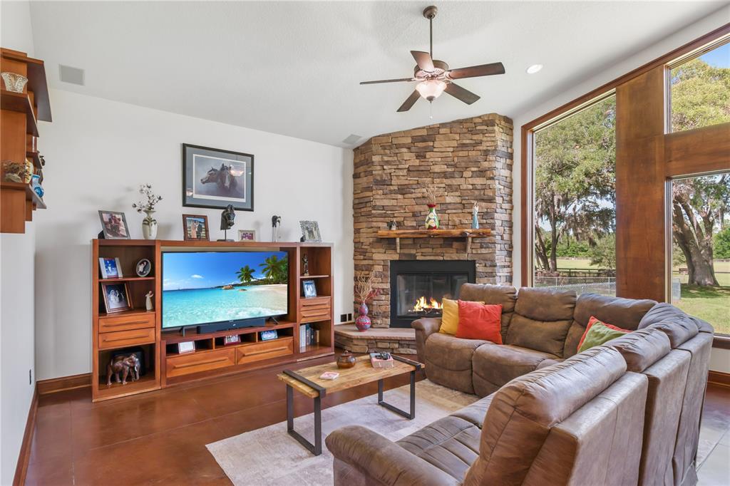6140 Northwest 145th Avenue Road Morriston, FL 32668 - Photo 14 of 75 a living room with furniture a fireplace and a flat screen tv