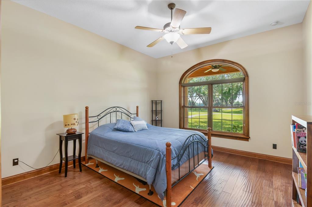 6140 Northwest 145th Avenue Road Morriston, FL 32668 - Photo 28 of 75 a bedroom with a bed a chandelier and a window