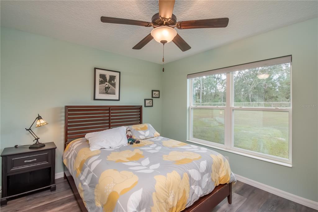 6140 Northwest 145th Avenue Road Morriston, FL 32668 - Photo 47 of 75 a bedroom with a bed and a chandelier