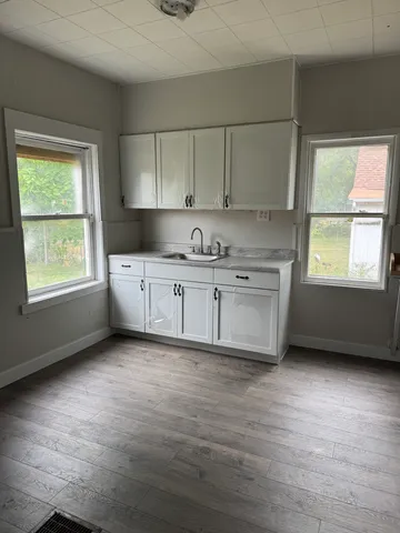a kitchen with stainless steel appliances granite countertop a sink window and cabinets