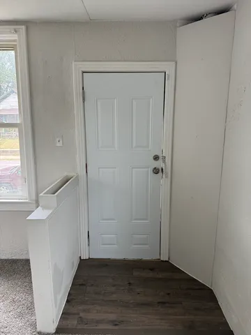 an empty room with wooden floor and a window