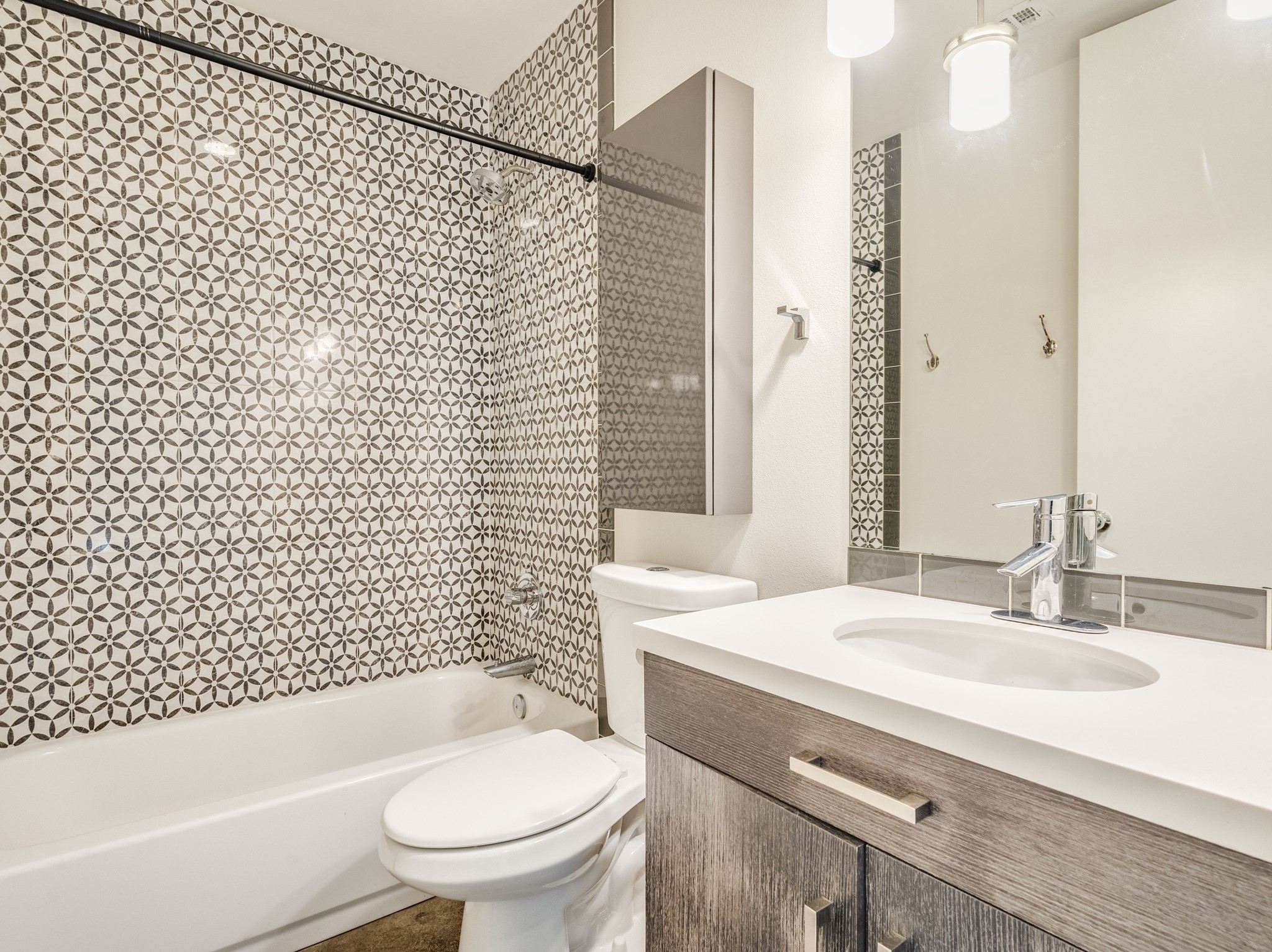 1404 Singleton Avenue, Unit B Austin, TX 78702 - Photo 17 of 21 Bold tiled walls enhance this bathroom, offering both tub and shower options alongside a sleek vanity.