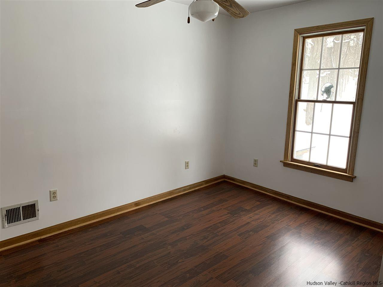 205 Union Center Road Ulster Park, NY 12487 - Photo 5 of 25 an empty room with wooden floor and windows