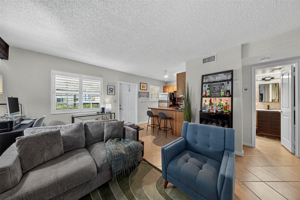2660 Northeast 8th Avenue, Unit 208 Wilton Manors, FL 33334 - Photo 12 of 49 a living room with furniture and a window