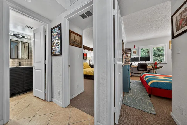 a bedroom with a bed and a lamp on dresser